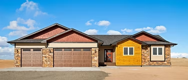 Alpine home exterior with stone, warm siding, and a three-car garage