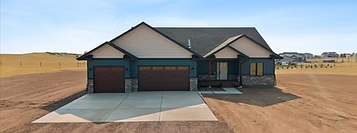 Dark green Triple Dot ranch home on open Wyoming land