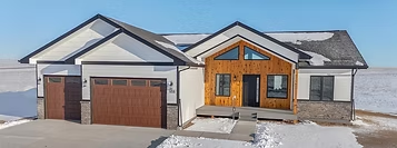 Light-colored Triple Dot home with timber entry accents in snow
